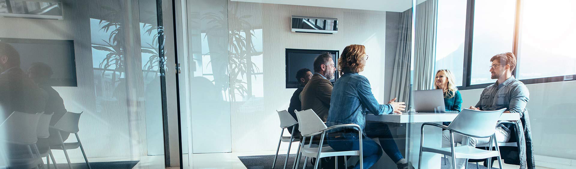 wide-angle shot, people sitting at a desk in a meeting